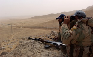 Deux soldats de l'armée syrienne observent les abords de Palmyre, jeudi 24 mars.
