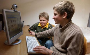 Des adolescents jouent dans leur chambre sur leur ordinateur.
