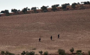 Des membres présumés du groupe Etat islamique sur une colline à l'ouest de Kobané, en Syrie le 18 octobre 2014