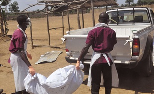 Des travailleurs de santé portent le corps d'une personne tuée par le virus Ebola, au Liberia le 27 février 2015.