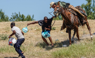 Un garde-frontière américain tente d'arrêter un migrant haïtien près du Rio Grande au Texas, le 19 septembre 2021.