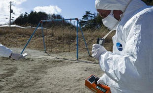 Un membre de Greenpeace mesure les niveaux de contamination radioactive dans une ville à 40km de Fukushima, au Japon, le 27 mars 2011.