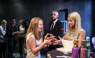 French blogger Marie Lopez, aka EnjoyPhoenix, receives a soft toy as a gift from a crying fan during a signing of her first book "Enjoy Marie" on June 17, 2015 in a cultural store in Lyon. AFP PHOTO / JEFF PACHOUD