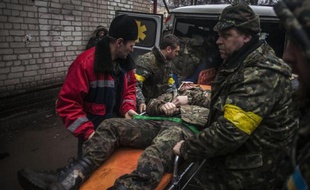 Des soldats ukrainiens transportent un des leurs, blessé lors d'affrontements avec des séparatistes à Artemivsk, le 2 février 2015