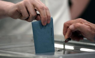 Un électeur dépose son bulletin dans l'urne pour le second tour des municipales, le 30 mars 2014 à Strasbourg