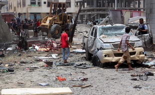 Des habitants d'Aden inspectent le lieu de l'attentat à la voiture piégée, le 29 août 2016.