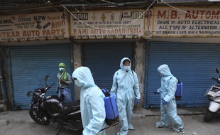 Des agents pulvérisent du désinfectant sur un marché de pièces de rechange automobile à New Delhi, le 18 mai 2020.