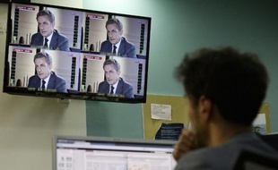 Un journaliste regarde l'interview de Nicolas Sarkozy, le 2 juillet 2014 à Paris