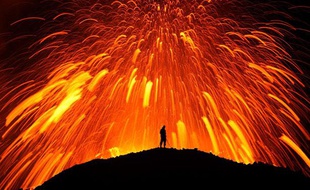 Un homme face à l'explosion d'un volcan, dans le glacier islandais Fimmvorduhals, près de Reykjavik, le 15 mai 2011
