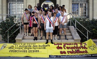 Ile-Saint-Denis Mayor Michel Bourgain (C) and local representatives pose in Des élus de l'Ile-Saint-Denis en petite tenue pour interpeller le gouvernement sur la baisse de la dotation budgétaire aux collectivités locales, le 29 novembre 2014