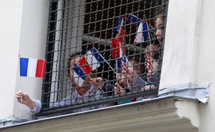 Des enfants affichent des drapeaux français à la fenêtre d'une école juive, au coeur de Paris pendant la visite de Bernard Cazeneuve.