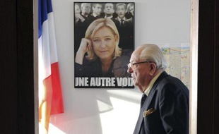 Le président d'honneur du Front national, Jean-Marie Le Pen, passe devant une affiche de sa fille à Agen le 12 janvier 2014