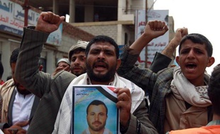 Des supporteurs des rebelles chiites, les houthis, brandissent les portraits de membres tués dans une attaque suicide cinq jours auparavant à Sanaa le 14 octobre 2014