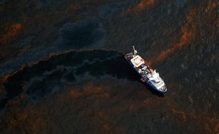 Le 28 avril 2010, un bateau est au milieu de la nappe de pétrole due à l'explosion de la platerforme pétrolière Deepwater, dans le Golfe du Mexique.