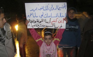 Une petite fille tient une pancarte de protestation contre le régime de Bachar al-Assad, le 3 mars 2012, à Homs (Syrie).