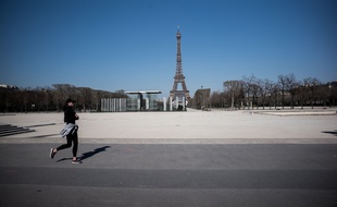 Une femme faisant son jogging, autour du Champs de Mars, à Paris, non loin de la Tour Eiffel.