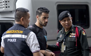 L'ancien joueur de l'équipe nationale de football de Bahreïn Hakeem Al-Araibi (au c.) en route pour le tribunal à Bangkok, le 11 décembre 2018.