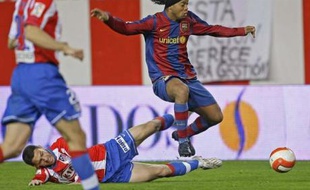 Le Brésilien Ronaldinho, à la lutte avec Maxi Rodriguez de l'Atletico Madrid, le 1er mars 2008.