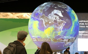 Des visiteurs regardent le globe terrestre au Bourget lors de la conférence sur le climat, le 10 décembre 2015