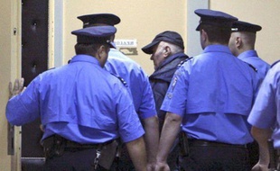 L'ancien chef militaire des Serbes de Bosnie, Ratko Mladic, entouré par des policiers après son arrestation, le 26 mai 2011.