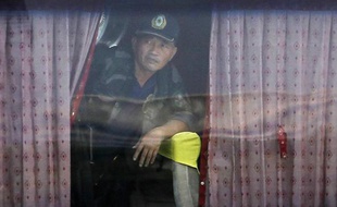 Le preneur d'otages Rolando Mendoza, à Manille, aux Philippes, regarde par la fenêtre du bus où il détient 16 personnes, lundi 23 août 2010.