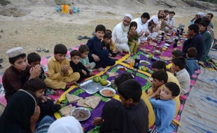 Gulzar Khan (au centre à gauche) au milieu de ses proches qui ont fui avec lui le Waziristan du Nord, alors qu'ils rompent le jeûne du Ramadan, le 11 juillet 2014 à Bannu
