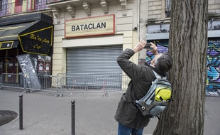 Une homme prend une photo du Bataclan le 19 mars dernier