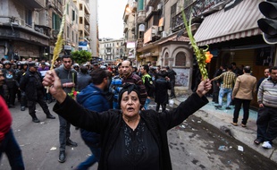 Une Egyptienne copte brandit des feuilles de palmiers, après l'attentat contre un lieu de culte à Alexandrie, en pleine cérémonie des Rameaux.