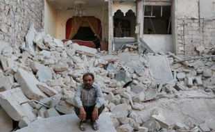Un habitant d'Alep sur le site d'un immeuble détruit par des raids aériens, en Syrie, le 13 juin 2014