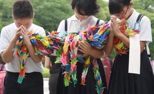 Des écoliers prient en hommage aux victimes de la bombe atomique lancée en 1945, à Hiroshima le 6 août 2014