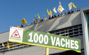 Des manifestants brandissent des affiches de la Confédération Paysanne pour protester contre le projet de ferme des 1000 vaches, le 12 septembre 2013 à Erquinghem-Lys dans le nord de la France