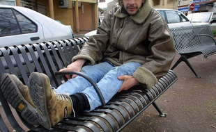 Un SDF présente l'exemple d'un banc anti sans-abri à Toulouse en 2005