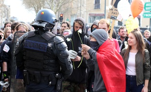 Des opposants à la loi Travail donnent des fleurs à un gendarme, ici lors d'une manifestation à Rennes le 5 avril 2016.