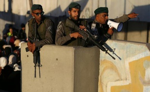 Des soldats israéliens surveillent des Palestiniens qui passent par le checkpoint de Qalandia, le 17 juin 2016