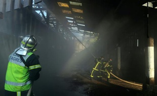 Un pompier à l'oeuvre dans un bâtiment squatté par des migrants à Caen, dans le nord-ouest de la France, le 25 avril 2016