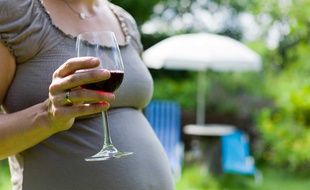 Illustration - Une femme enceinte qui boit un verre d'alcool