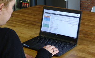 Une mère consulte la plateforme Pronote.