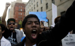 Un manifestant crie lors d'une marche pour réclamer justice après la mort d'un jeune Noir et protester contre les violences policières, à Baltimore le 29 avril 2015