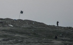 Un drapeau du groupe Etat islamique sur la colline de Tilsehir dans le village de Yumurtalik, dans la province de Sanliurfa en Syrie