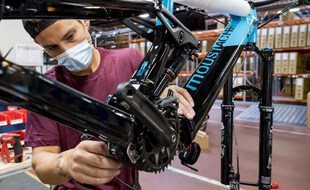 Un employé assemble un VTT électrique à l'usine Moustache Bikes le 28 août 2020, à Thaon-les-Vosges, dans l'est de la France.