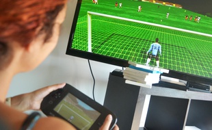 Une joueuse joue à un célèbre jeu vidéo de football (Illustration).