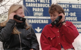 Deux jeunes femmes passent des communications à l'aide du nouveau téléphone