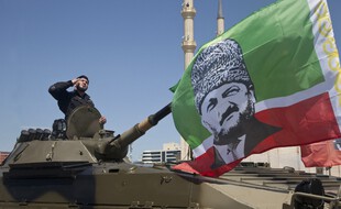 Un membre de l'armée tchétchène avec le portrait du président Ramzan Kadyrov à Grozny, le 9 mai 2013.