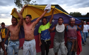 Des opposants au président Nicolas Maduro font flotter le drapeau vénézuelien à la frontière avec le Brésil.