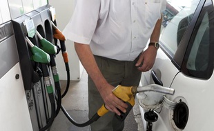 Un homme fait le plein d'essence dans une station service.