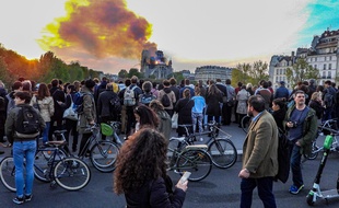 Des passants observent l'incendie de Notre-Dame de Paris le 15 avril 2019