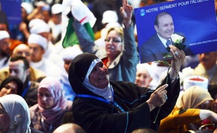 Une militante brandit le portrait du président algérien Abdelaziz Bouteflika le 13 avril 2014 à Alger