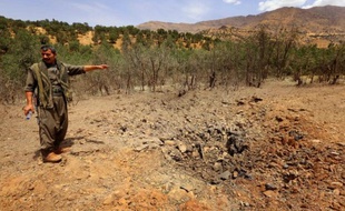 Un membre du Parti des travailleurs du Kurdistan (PKK) inspecte un cratère causé par un raid de l'armée turque, sur le mont Qandil au nord de l'Irak, le 29 juillet 2015