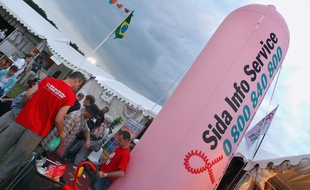 Longchamp, le 5 juillet 2003. Des personnes se renseignent sur le stand de l'association Sida Info Service lors du festival Solidays.