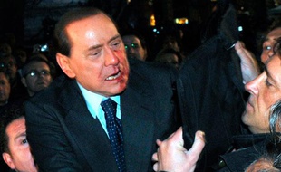 Le Premier ministre italien Silvio Berlusconi est secouru par la police après avoir été attaqué par un homme lors d'un meeting électoral, Milan, le 13 décembre 2009.